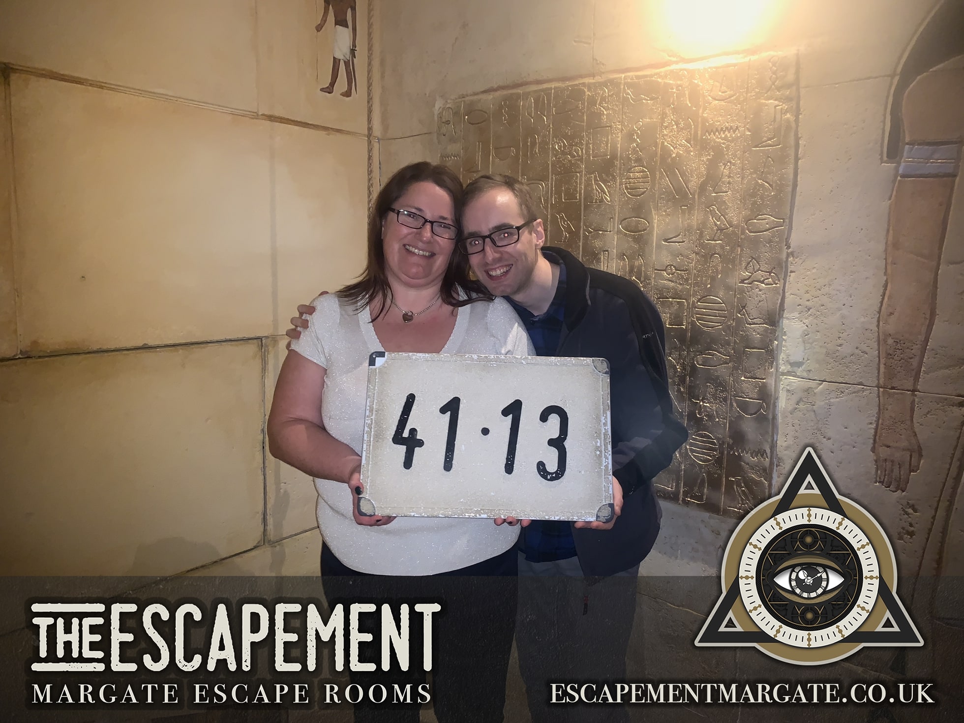 Anthony and Trenna pose after Egyptian Tomb at The Escapement, holding a finish-time board in an Egyptian-themed room.