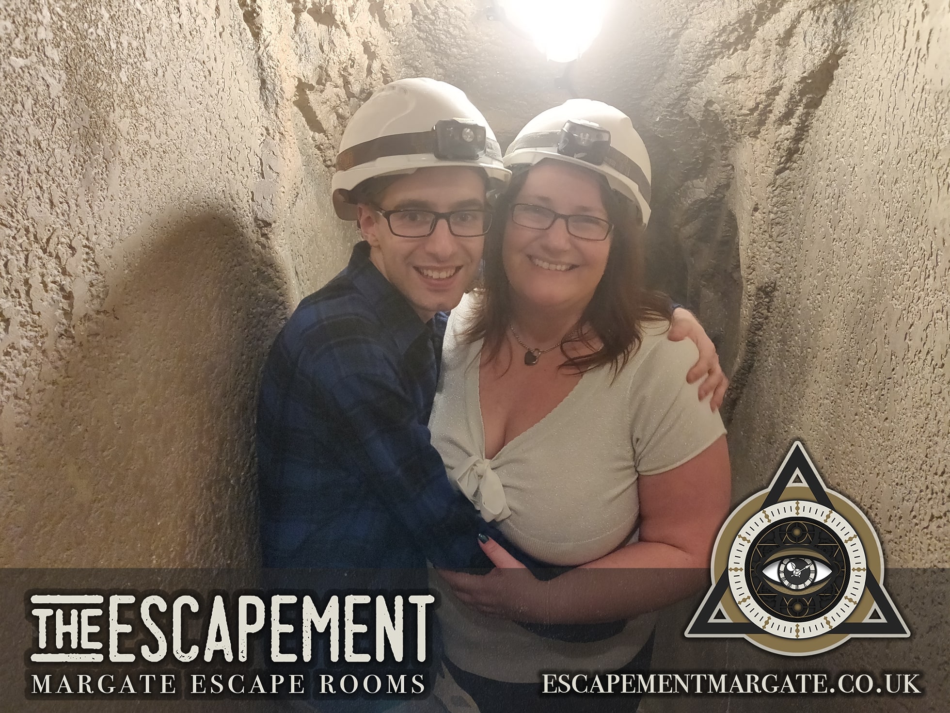 Anthony and Trenna pose after The Pit at The Escapement, wearing hard hats in a narrow tunnel.