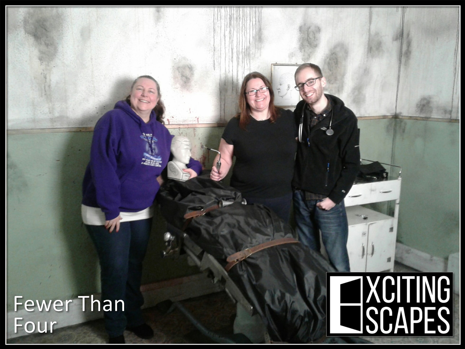 A three-person team pose after The voices we hear at Exciting Escapes, in a medical-themed room.