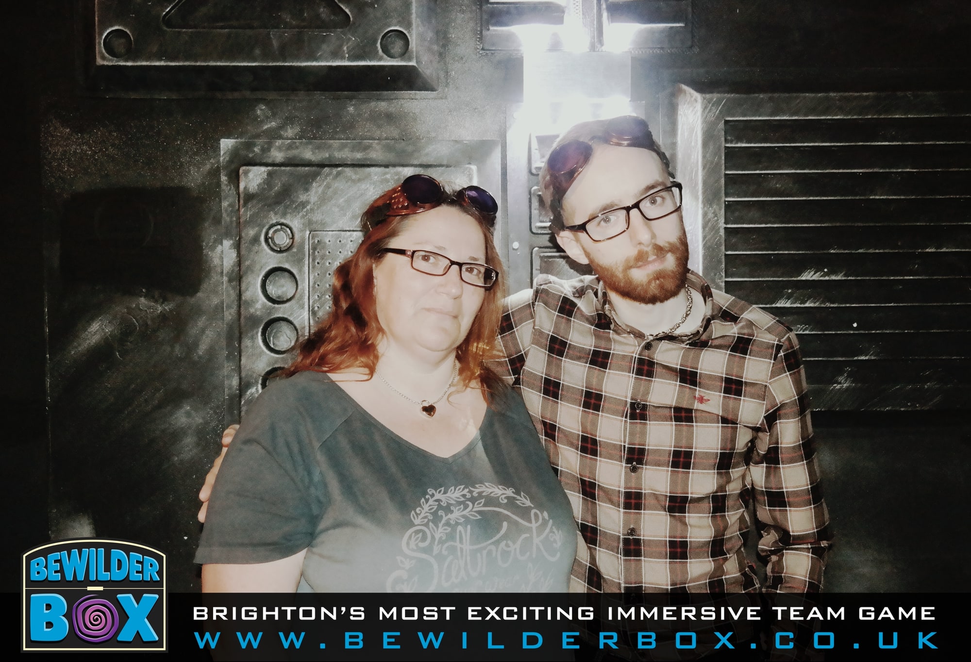 Anthony and Trenna pose after Bewilderbox initiative at BewilderBox, wearing goggles in the Bewilder Box control-room setting.