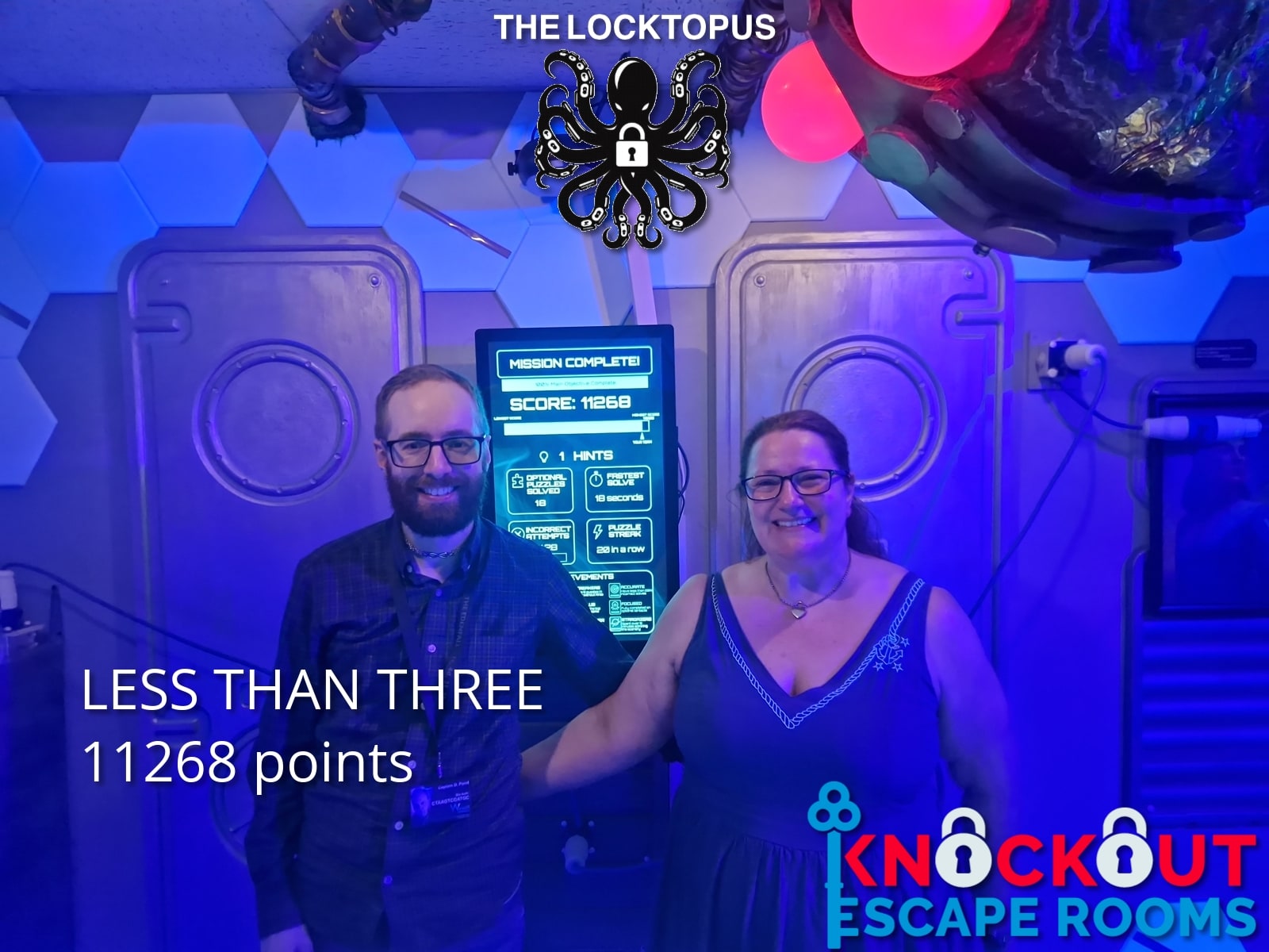 Anthony and Trenna pose after Loctopus at Knock Out Escape Rooms, in the blue-lit Locktopus room beside the mission-complete screen.